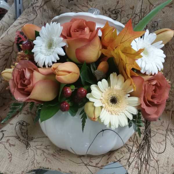 Mixed bouquet in a white pumpkin-shaped vase with roses and daisies