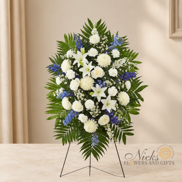 Standing floral spray with white and blue flowers on a metal easel
