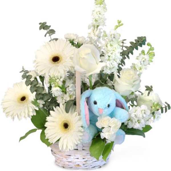 White flowers in a basket with a blue plush bunny