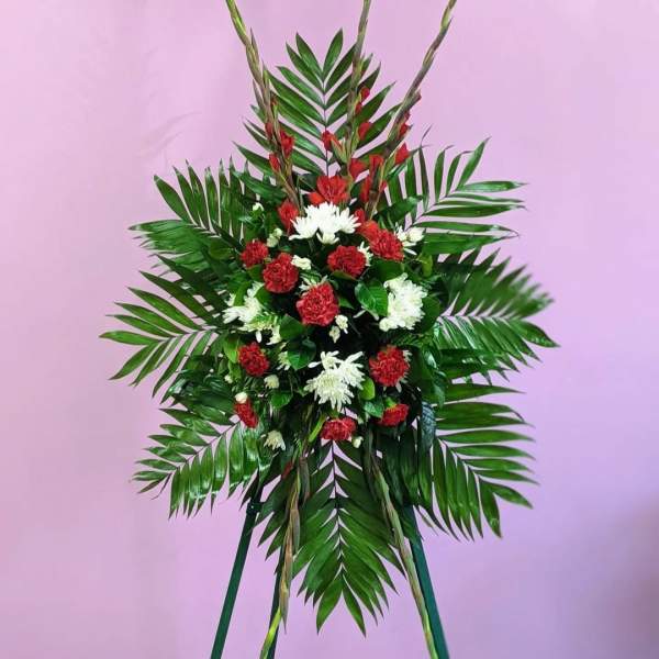 Standing floral spray with red and white flowers and palm fronds