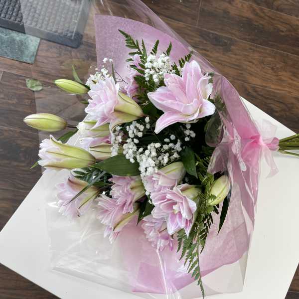 Pink lilies and white filler flowers wrapped in pink paper