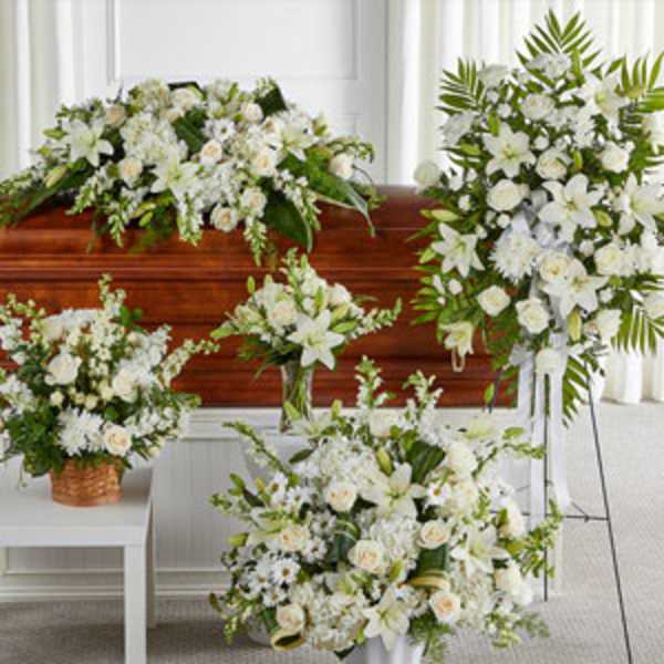 White floral funeral arrangements around a casket