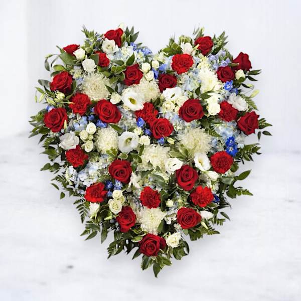 Heart-shaped floral arrangement with red, white, and blue flowers
