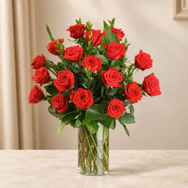 Red roses arranged in a clear glass vase