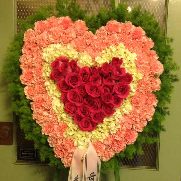 Heart-shaped standing floral spray with red roses and pink carnations