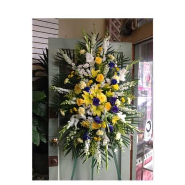 Tall standing floral spray with yellow, white, and purple flowers