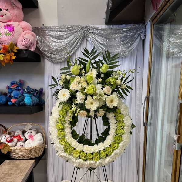 Large standing floral wreath with white and green flowers on an easel
