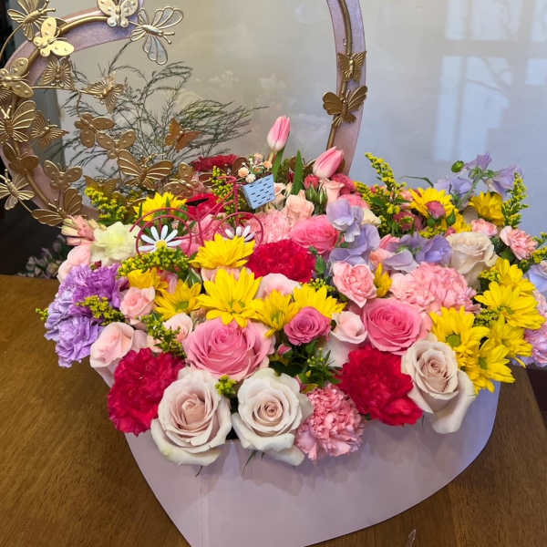 Heart-shaped flower basket with pink, yellow, purple, and white blooms