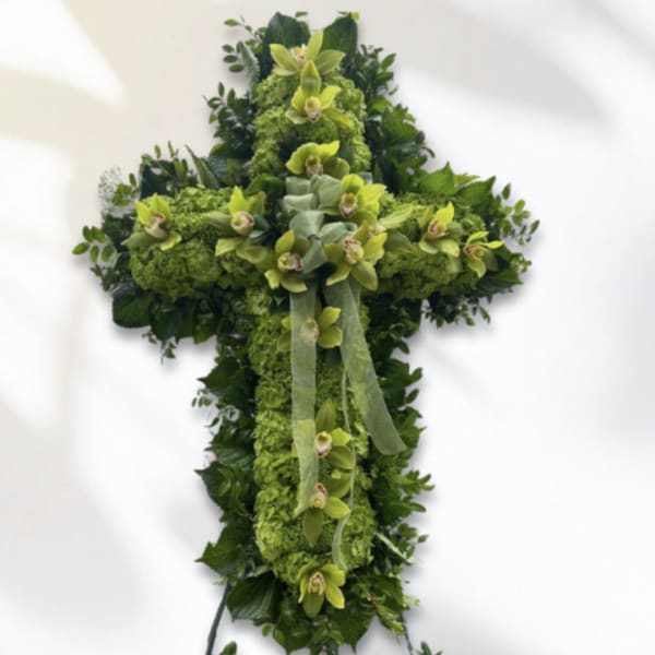 Green floral cross with orchids and ribbon on a white background