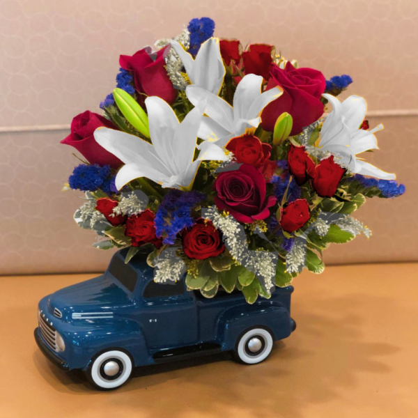 Bouquet of red roses and white lilies in a blue truck container