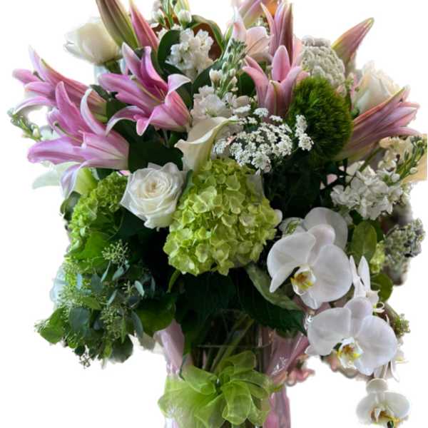 Pink lilies and white orchids in a pink-wrapped vase arrangement