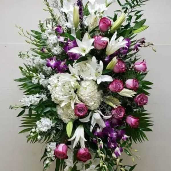 Tall standing floral spray with white lilies, pink roses, and purple orchids