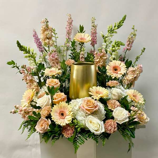 Large floral arrangement with peach roses, white blooms, and a gold vase centerpiece