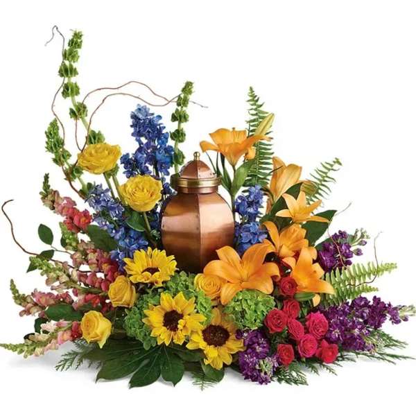 Colorful floral arrangement around a copper urn