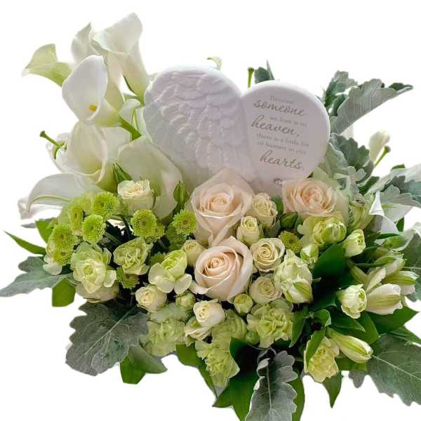 White calla lilies and pale roses with a memorial heart plaque