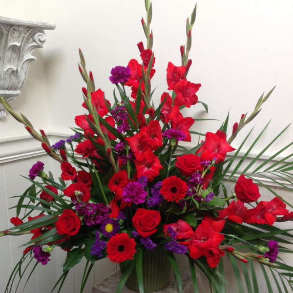 Tall red and purple floral arrangement in a vase