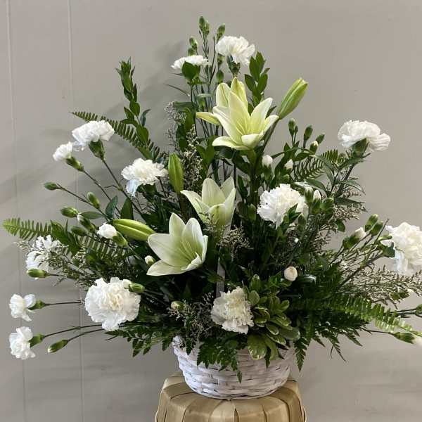 White lilies and carnations in a white basket
