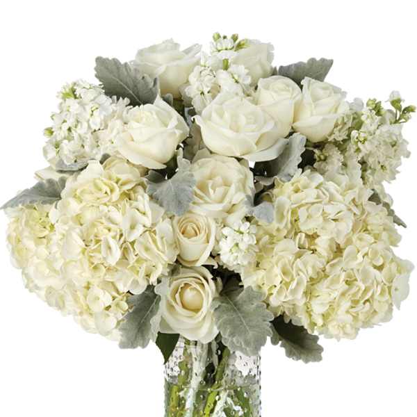 White roses and hydrangeas in a clear glass vase