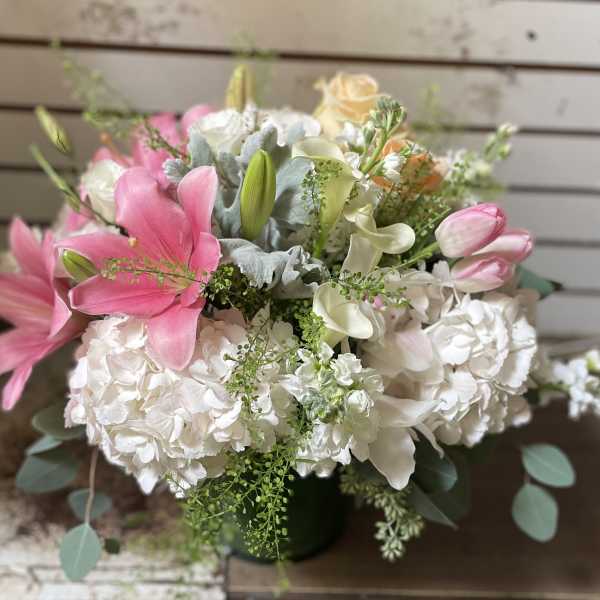 Pink lilies and white hydrangeas in a dark vase