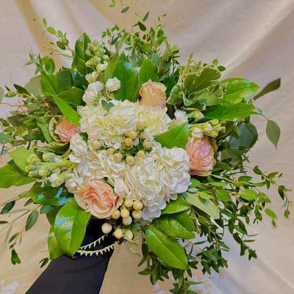 Bouquet of white hydrangeas and pale pink roses with greenery