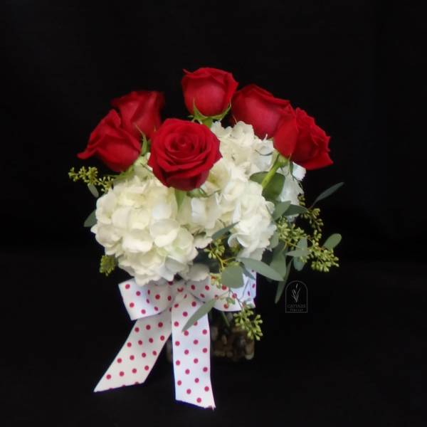 Bouquet of red roses and white hydrangeas with a polka-dot ribbon