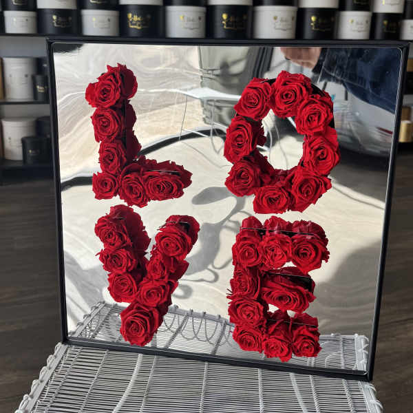 Red roses arranged as the numbers 1, 0, 1, and 5 in a mirrored frame