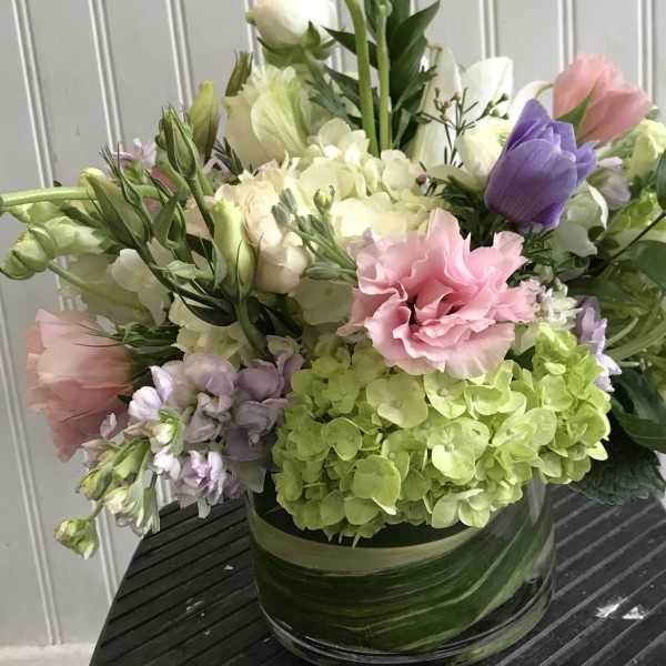 Mixed bouquet in a glass vase with pink, purple, white, and green blooms