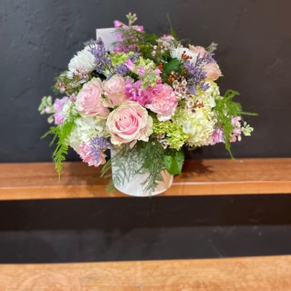 Pink and white rose bouquet with mixed pastel flowers in a white vase