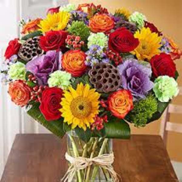 Mixed bouquet of roses, gerbera daisies, and carnations in a glass vase