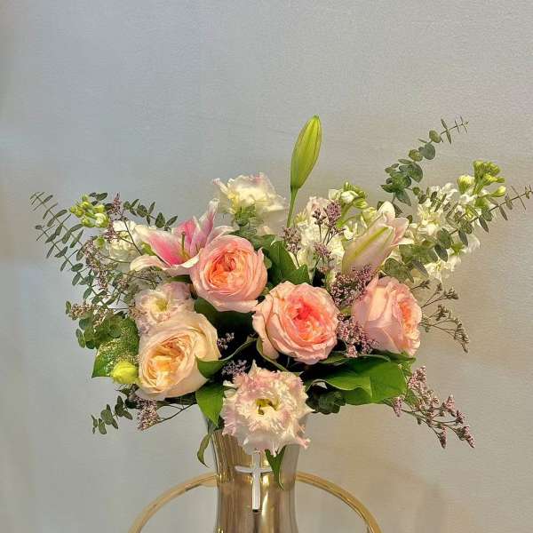 Pink roses and lilies arranged in a clear vase