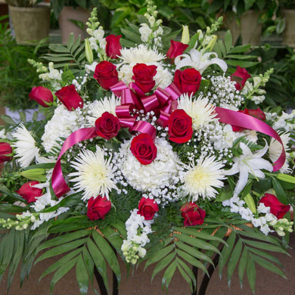 Large red and white floral spray with pink ribbon