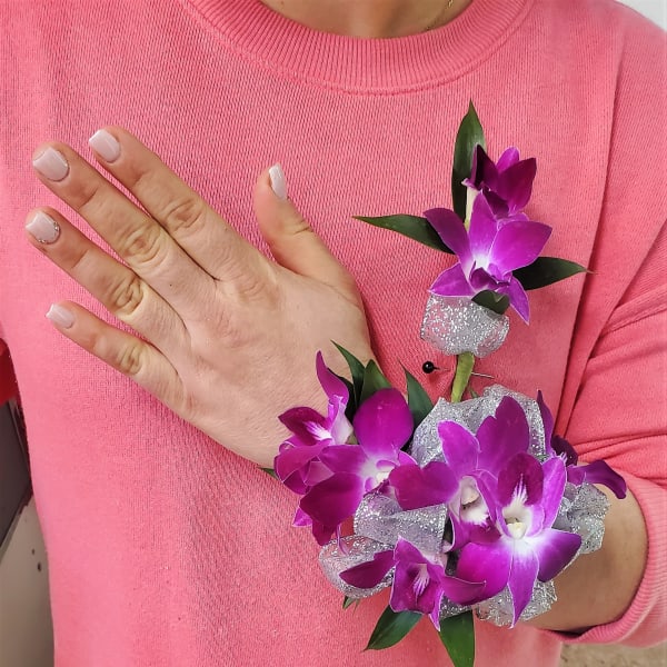 Woman wearing a purple orchid corsage and matching wristlet