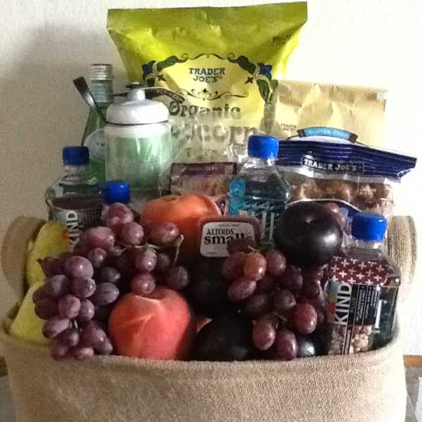 Gift basket filled with fruit, snacks, and bottled drinks