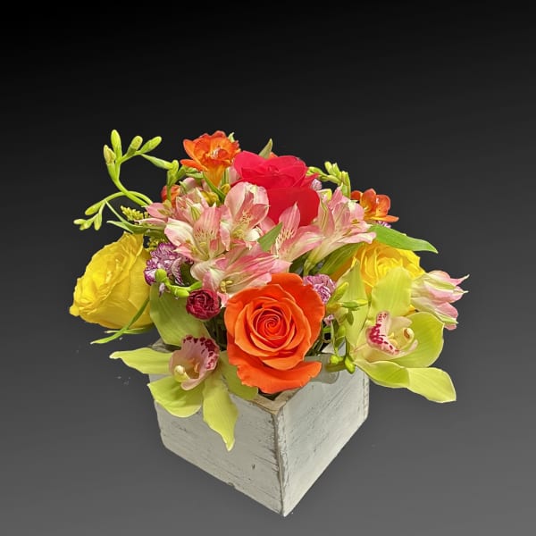 Mixed bouquet in a white wooden box with roses and orchids