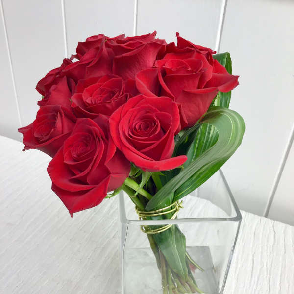 Bouquet of red roses in a clear square vase