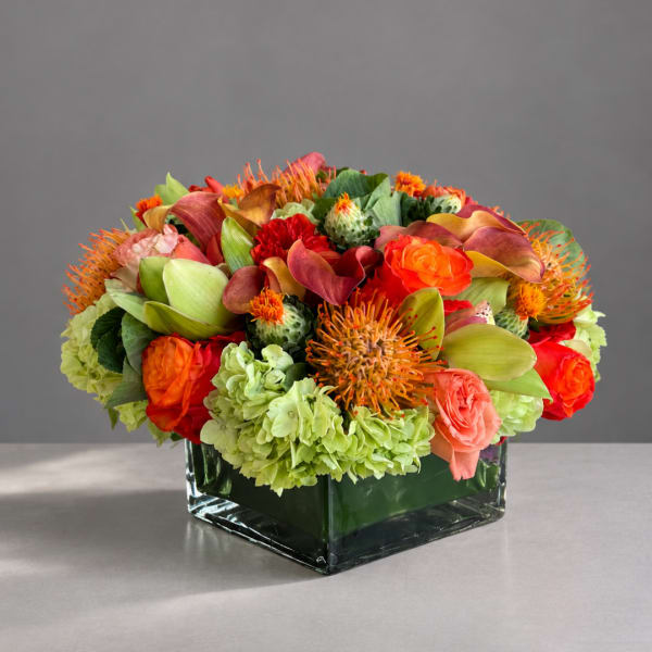 Colorful floral arrangement in a square glass vase