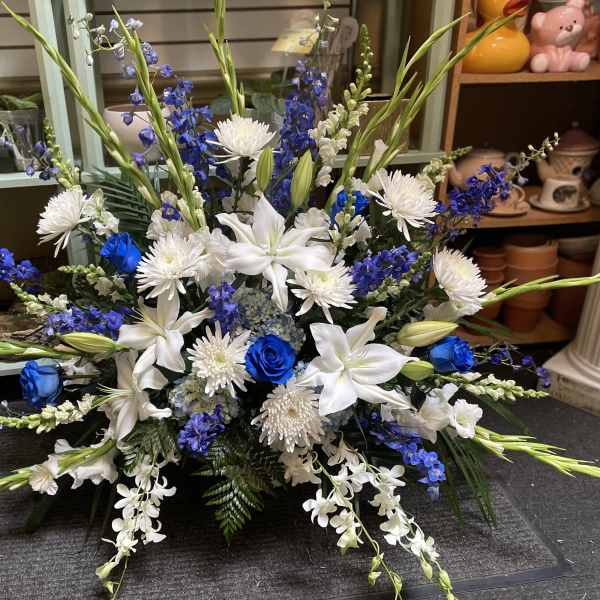 Blue and white floral arrangement with lilies and roses