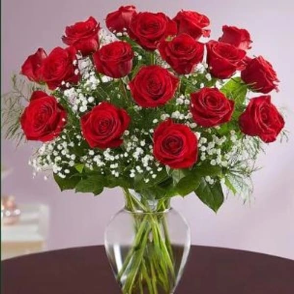 Bouquet of red roses with baby's breath in a clear glass vase