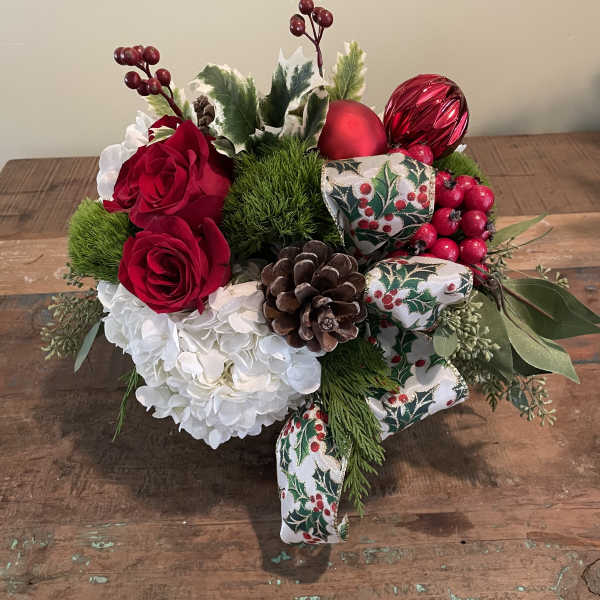 Holiday bouquet with red roses, white hydrangea, pinecones, and ribbon