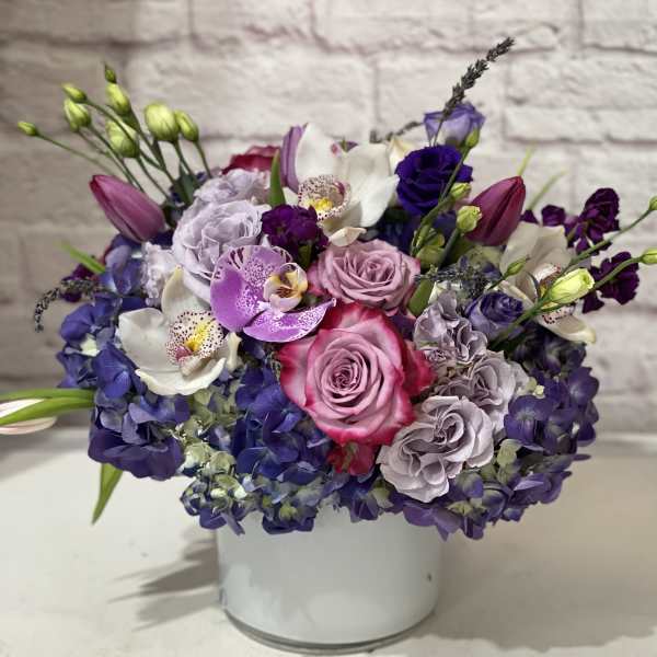 Bouquet of pink, purple, and white flowers in a white vase