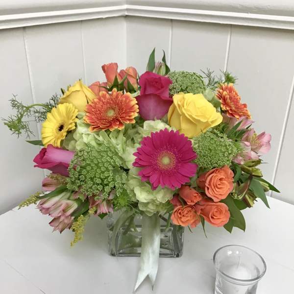 Colorful bouquet of roses, gerbera daisies, and hydrangeas in a glass vase