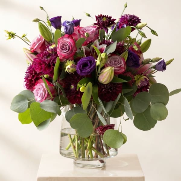 Bouquet of pink and purple flowers in a clear glass vase