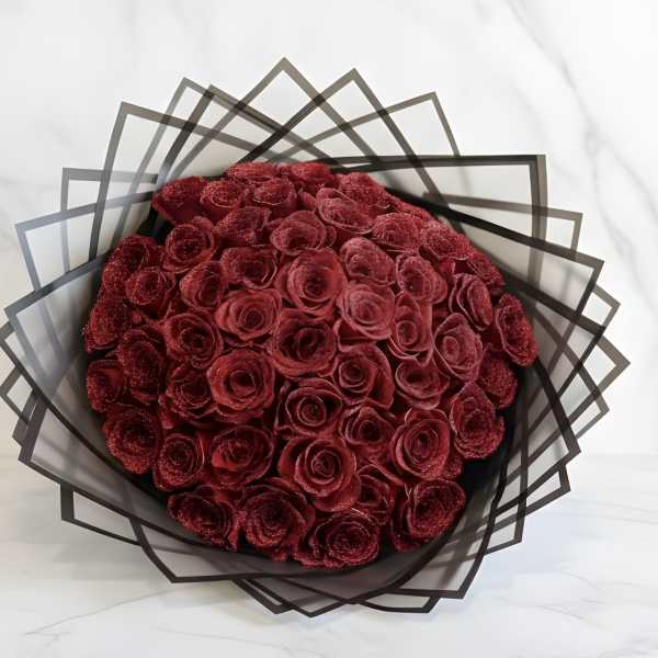 Bouquet of deep red roses wrapped in geometric black paper