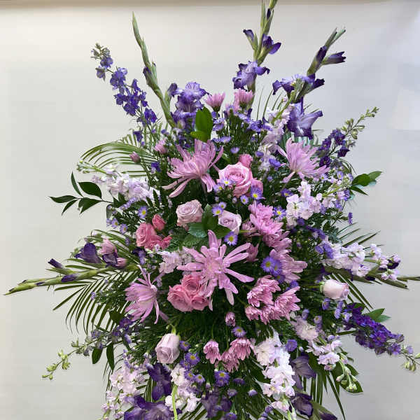 Large standing spray of pink and purple flowers on a metal easel