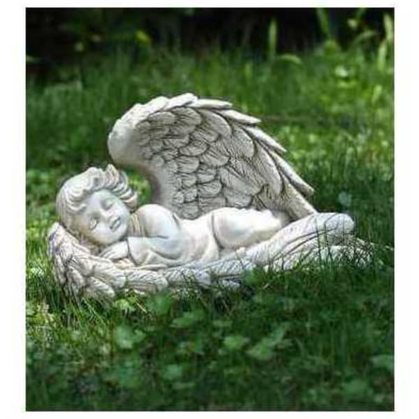 Stone angel statue lying in grass outdoors