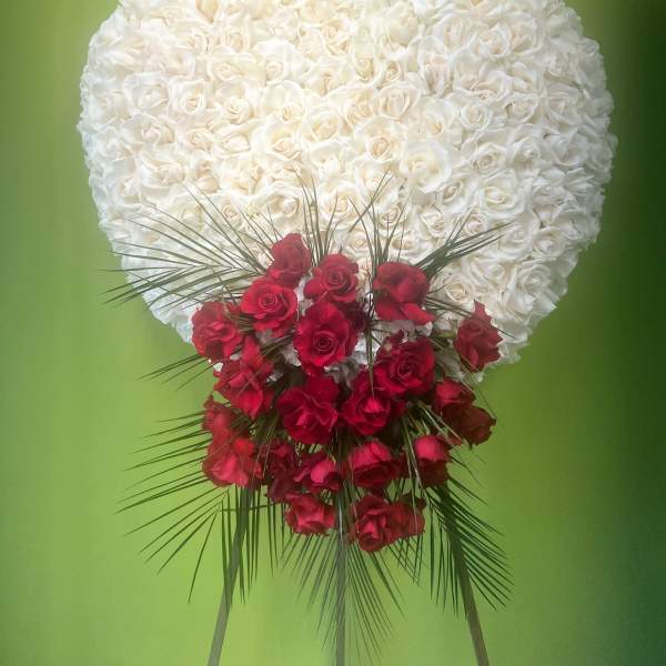 Heart-shaped white rose arrangement with red roses at the base
