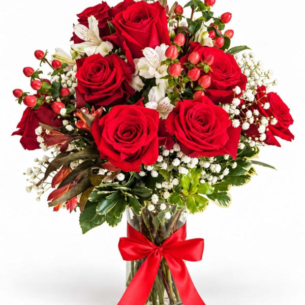 Bouquet of red roses and white flowers in a glass vase with a red ribbon