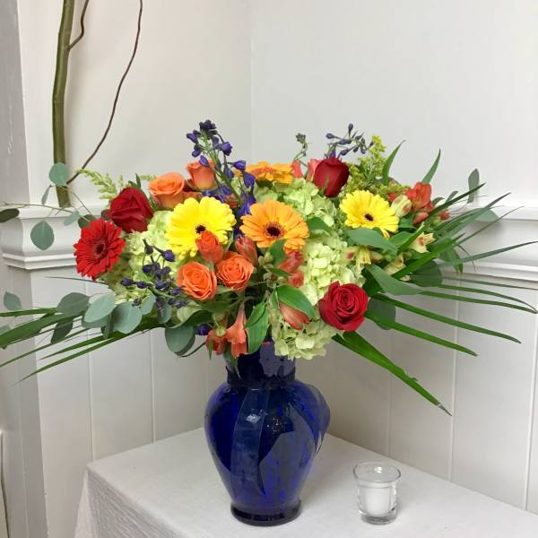 Colorful mixed bouquet in a blue glass vase