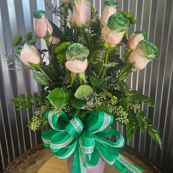 Pink roses in a vase with green ribbon and glittered accents