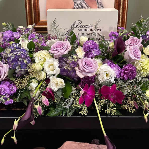Large purple and white floral casket spray with roses and orchids